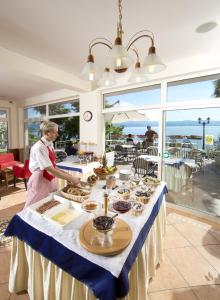 a man standing in front of a table with food at Hotel Stanger in Lovran