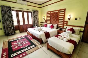 um quarto de hotel com duas camas e uma janela em ELEPHANT ROUTE em Thekkady