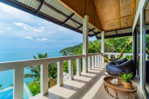 Un balcón con una hamaca y el océano en White Azure Villa Two, en Than Sadet Beach