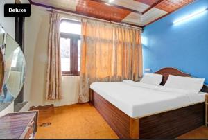 Un dormitorio con una gran cama blanca y una ventana en Nishat lake view resort, en Srinagar