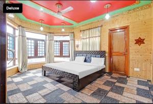 ein Schlafzimmer mit einem großen Bett in einem Zimmer mit Fenstern in der Unterkunft Nishat lake view resort in Srinagar
