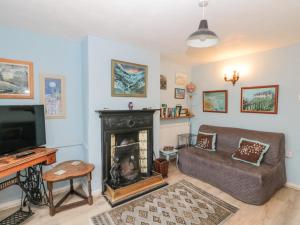 uma sala de estar com um sofá e uma lareira em Cliff Top Cottage em Saltburn-by-the-Sea