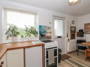 uma cozinha com armários brancos e um fogão em Cliff Top Cottage em Saltburn-by-the-Sea