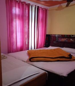 um quarto com 2 camas individuais e cortinas cor-de-rosa em Shani Homestay by StayApart em Barkot