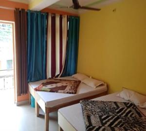 um quarto com duas camas e uma janela com em Shani Homestay by StayApart em Barkot