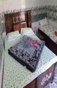 duas camas num quarto com flores em Shani Homestay by StayApart em Barkot