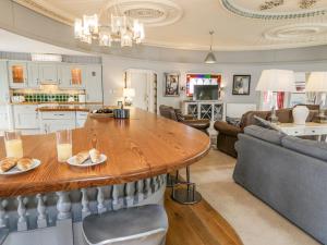 a kitchen and living room with a large wooden table at Capel Mawr in Llanrug