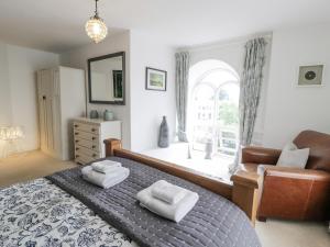 - une chambre avec un lit, une chaise et une fenêtre dans l'établissement Capel Mawr, à Llanrug