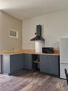 una cocina vacía con encimera y microondas en appartement, en Limeyrat