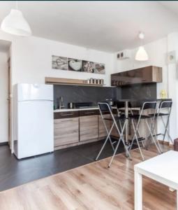 a kitchen with a refrigerator and a table and chairs at Apartament Centrum przy Wiśle, Żydowska dzielnica in Krakow