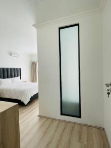 een witte kamer met een spiegel en een bed bij Stay In Carlazo - Unlimited WiFi, Solar backup in Roodepoort
