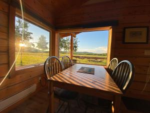 a dining room with a table and chairs and a window at Oma's and Opa's Northern Lights Viewing Cabin in Whitehorse