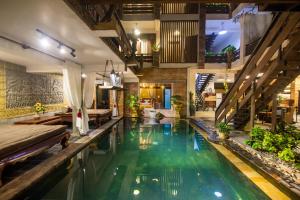 an indoor pool with green water in a house at Cambana d'Angkor Suites in Siem Reap