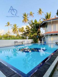 a large swimming pool in front of a house at Aquamarine Weligama in Weligama