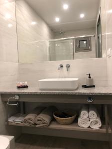 a bathroom with a sink and towels on a counter at Anassa Resort Halkidiki - Adults only in Kalivia Poligirou