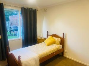 Un dormitorio con una cama con almohadas amarillas y una ventana en Cottage with ample outdoor area, en Berwick