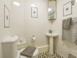 a white bathroom with a toilet and a sink at SoundView in Plymouth +15 photos