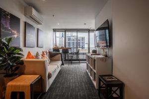 un soggiorno con divano e TV di ‘Sunrise on Aura’ Apartment with stunning views. a Melbourne