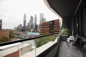 uma varanda com cadeiras e vista para a cidade em ‘Sunrise on Aura’ Apartment with stunning views. em Melbourne