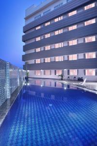 a swimming pool in front of a building at favehotel Jababeka Cikarang in Cikarang