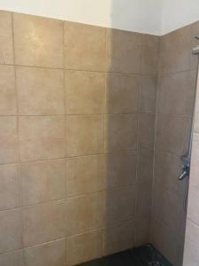 W łazience znajduje się prysznic ze ścianą wyłożoną kafelkami. w obiekcie Punaauia Panoramic View w mieście Punaauia