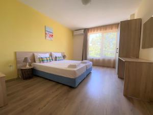 a bedroom with a bed and a window at Solei Apartments in Primorsko