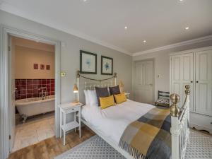 a bedroom with a large bed and a bath tub at Blackberry Lodge in Ashburton