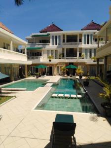 a large building with a swimming pool in front of it at Bali Court Hotel & Apartment in Legian