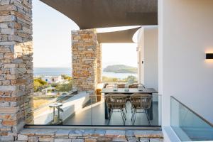 a patio with a table and chairs on a balcony at Koumbara Sea View in Ios Chora