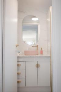 a bathroom with a pink sink and a mirror at Malie - By The Sea in Torquay