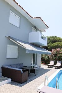 un patio con sofá y piscina en VILLA LIA-SKIATHOS-PRIVATE POOL-, en Skiathos