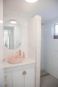 a bathroom with a pink sink and a mirror at Malie - By The Sea in Torquay