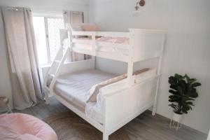 a white bunk bed in a room with a window at Malie - By The Sea in Torquay