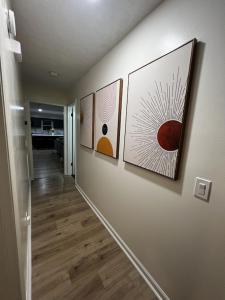 a hallway with four paintings on a wall at Spacious & Cozy - Close to Fort Moore - Pool Table in Columbus