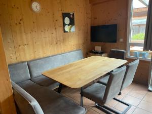 uma sala de jantar com uma mesa de madeira e cadeiras em Chalet Sternwarte em Hohentauern
