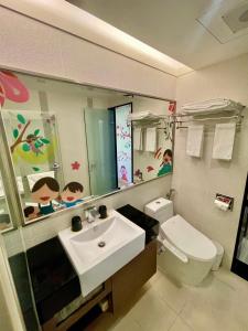 uma casa de banho com um lavatório, um WC e um espelho. em Morn Sun Hotel em Changhua County