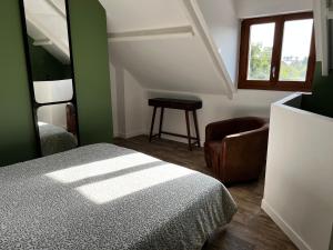 - une chambre avec un lit, une chaise et une fenêtre dans l'établissement Domaine de la Ville Chérel, maison à colombage, à Pontorson
