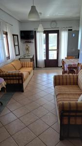 a living room with couches and a tile floor at Βlueview in Ermioni