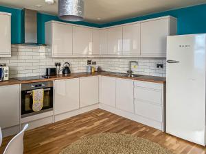 a kitchen with white cabinets and a refrigerator at The Lookout in Scarborough