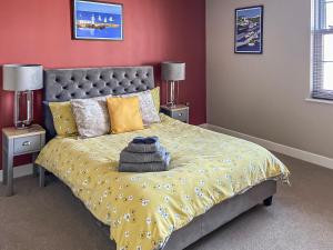 a bedroom with a bed with a yellow comforter and two lamps at The Lookout in Scarborough