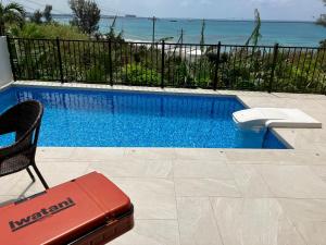 una piscina con una maleta roja al lado de un dstg en -Villa Rikyu- 離宮, en Isla Miyako