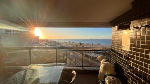 a balcony with a view of the beach at sunset at Beira Mar Fortaleza Landscape Luxo in Fortaleza