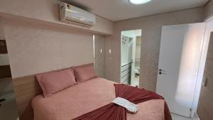 um quarto com uma cama com um cobertor rosa em Beira Mar Fortaleza Landscape Luxo em Fortaleza