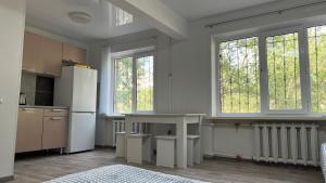 a kitchen with a table and some windows at Luxe-kvartira in Balqash