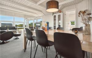 een eetkamer met een grote houten tafel en stoelen bij Beautiful Home In Bjert With House Sea View in Sønder Bjert
