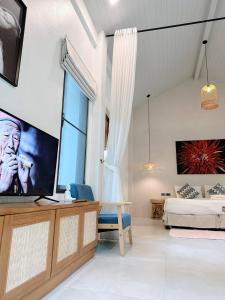 a living room with a bed and a large screen tv at Crystal 7 in Haad Tian