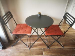 a table with two chairs and a table with a cup on it at Appartement Indépendant à Terrerort in Saumur