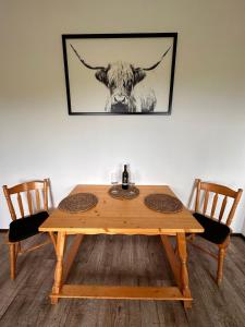 einem Holztisch mit einem Kuhkopf an der Wand in der Unterkunft Glanz und Gloria Weingartenapartment an der Kellerstraße, viele Buschenschänke, sehr ruhige Lage, herrliche Aussicht! in Leutschach