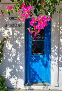 een blauwe deur met roze bloemen op een wit gebouw bij Chez Cécile Home in Mochlos