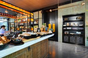 un restaurant avec un comptoir avec une personne préparant des repas dans l'établissement Publica Isrotel, Autograph Collection, à Herzliya 60 autres photos